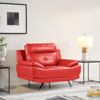Red leather armchair in a modern living room setting with a lamp and framed picture on the wall.
