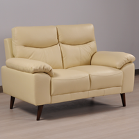 Angled view of the Vantage Cream 2-Seater Sofa in a modern living room setting with stylish décor and neutral tones