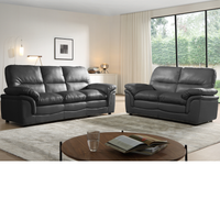 Gray leather sofa set in a living room with a coffee table and decor items.