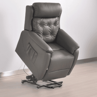 Gray leather recliner chair on a light wooden floor with a white wall background