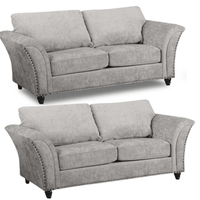 Two gray sofas with nailhead trim on a white background