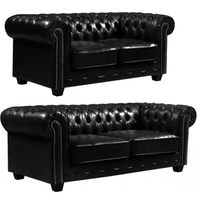Two black leather sofas with tufted backrests on a white background