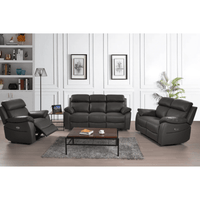 Black leather reclining sofa set in a living room setting with a coffee table and decor.