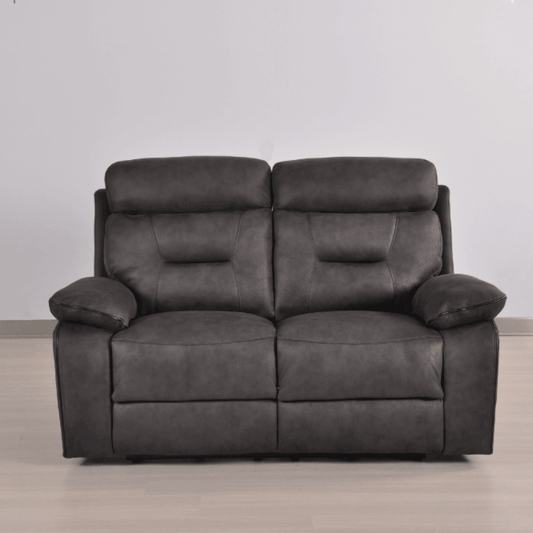 Gray leather sofa on a wooden floor with a plain white wall background