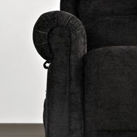 Close-up of a dark gray upholstered chair with armrest detail.