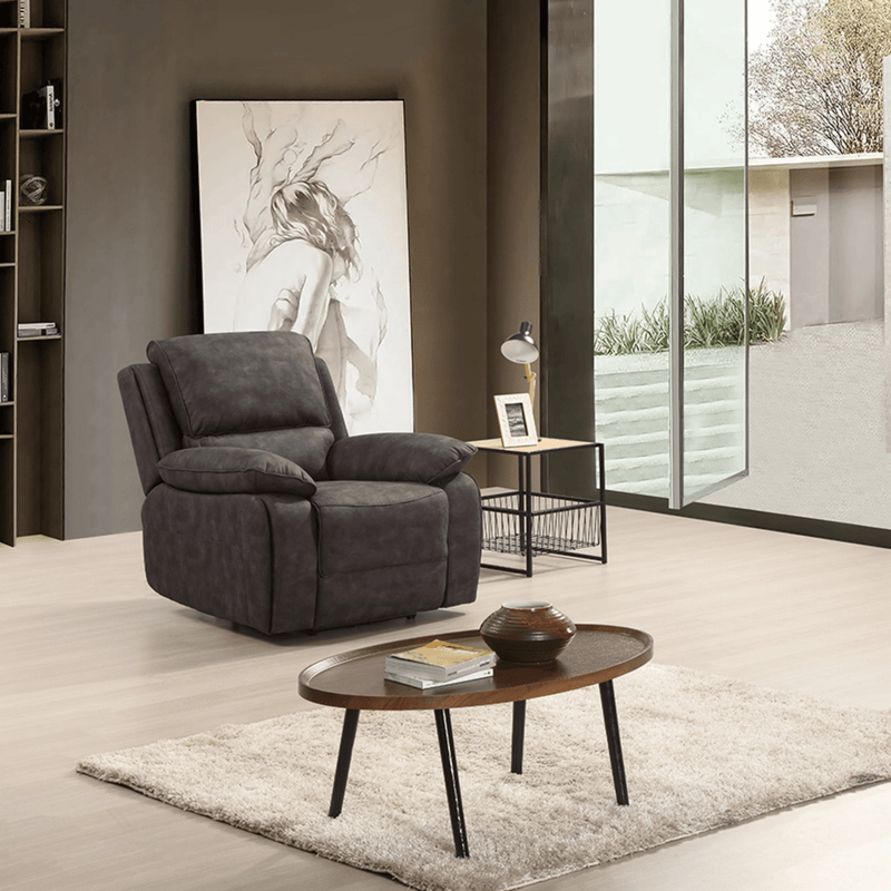 Gray armchair in a modern living room with a coffee table and decorative items.