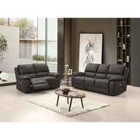Gray reclining sofa set in a modern living room with a coffee table and decor.