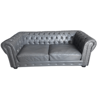 Gray tufted leather sofa on a white background