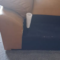 White cylindrical object on a beige couch with a dark floor.