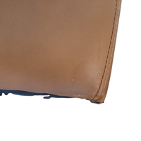 Close-up of a brown leather product with visible stitching on a white background