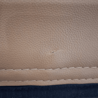 Close-up of a beige leather surface with a small scratch.