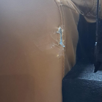 Close-up of a leather surface with visible wear and tear.