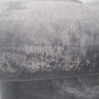 A close-up of a textured gray fabric, showing a mottled pattern with lighter and darker gray areas.