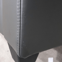 close up of grey leather sofa of marks on corner.