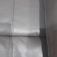 Close-up detail of the Valerie grey leather armchair showcasing texture