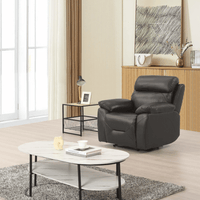 Gray recliner chair in a living room with a coffee table and decor items.