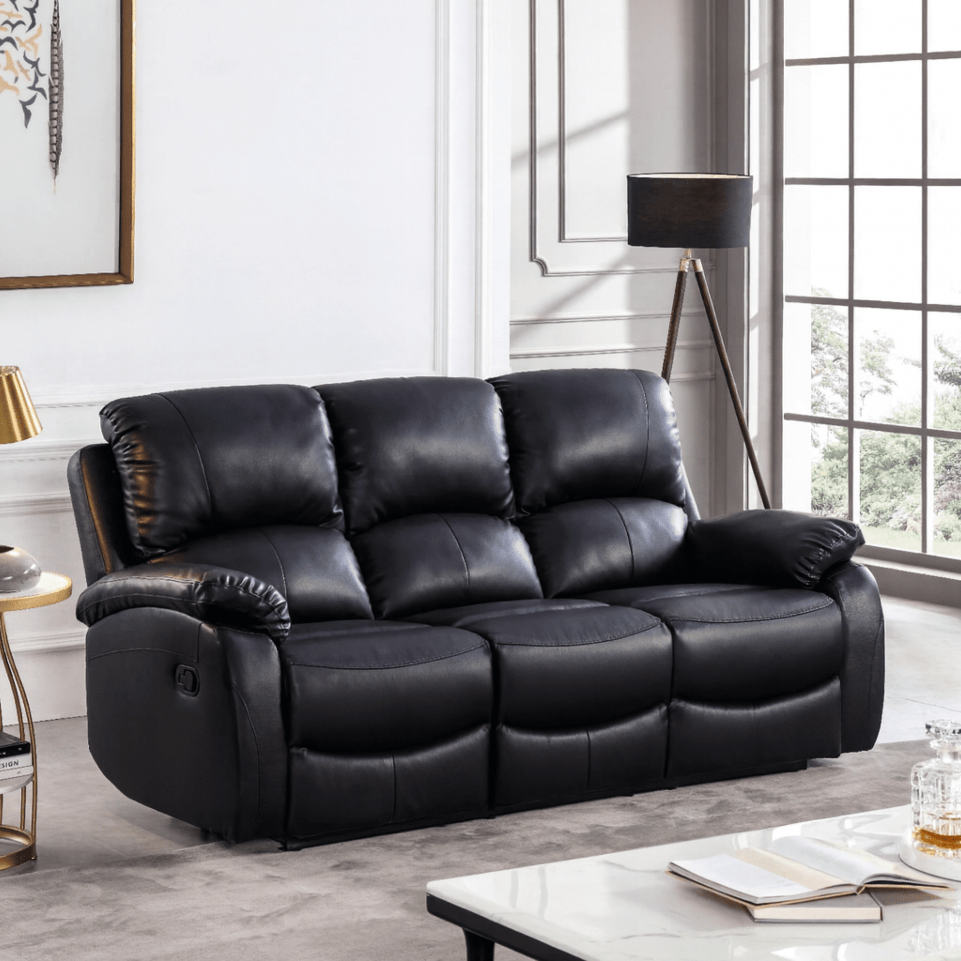 Black leather sofa in a living room setting with a lamp and table.