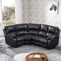 Black leather sectional sofa in a living room setting with a coffee table and decor items.