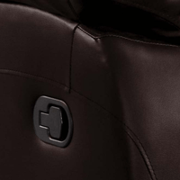 Close-up of a black leather surface with a metallic logo.