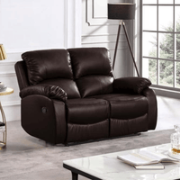 Brown leather recliner sofa in a living room setting with a lamp and table.
