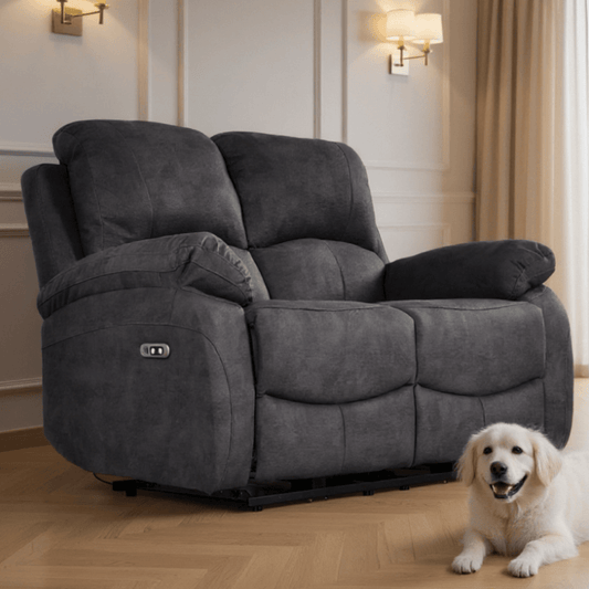 Gray recliner sofa in a living room with a white dog sitting next to it.