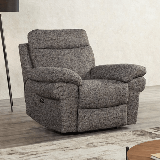 Gray recliner chair in a room with a wooden floor and a lamp.