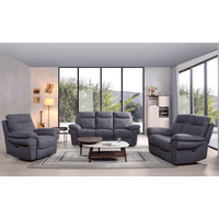 Gray sofa set in a modern living room with large windows.