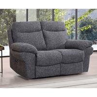 Gray recliner sofa in a room with large windows showing greenery outside.
