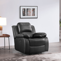 Black leather recliner chair in a living room setting with a lamp and framed picture on the wall.