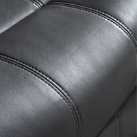 Close-up of a gray leather armchair with visible stitching.