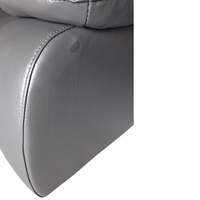 Close-up of a gray upholstered chair or sofa arm with visible stitching and a small oval control button on the side, shown against a white background.