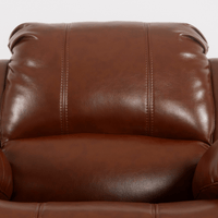 Close-up of a brown leather sofa with visible stitching.