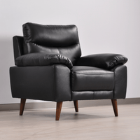 Vantage black armchair in a modern living room set, angled view with decor and soft ambient lighting.