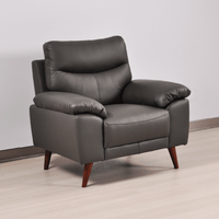 Vantage Grey Armchair angled view in living room set, highlighting cushions, fabric texture, and modern design details