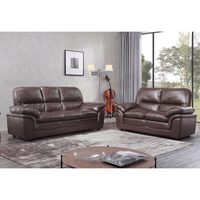 Brown leather sofa set in a living room with a rug and coffee table.
