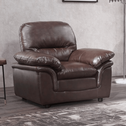 Brown leather armchair in a room with a neutral wall and floor.