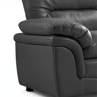 Close-up of a dark gray leather recliner chair on a white background close up