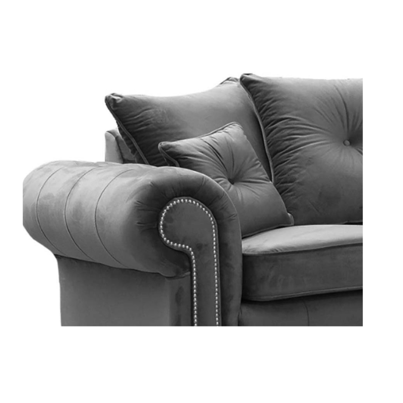 Grey velvet sofa with decorative pillows on a white background