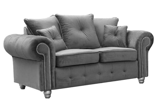 Gray sofa with tufted backrest and decorative pillows on a white background