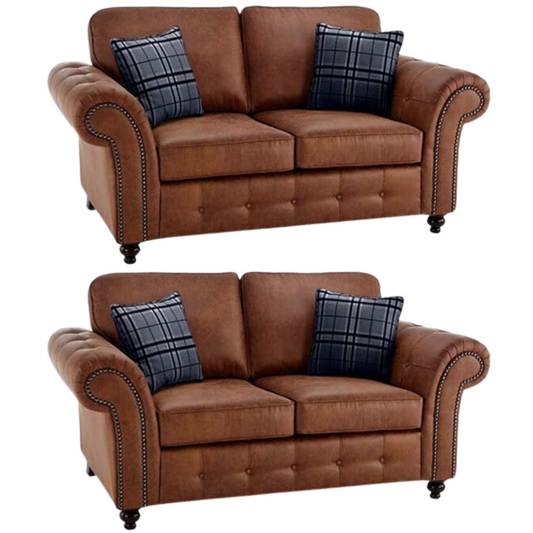 Two brown fabric  sofas with plaid cushions on a white background