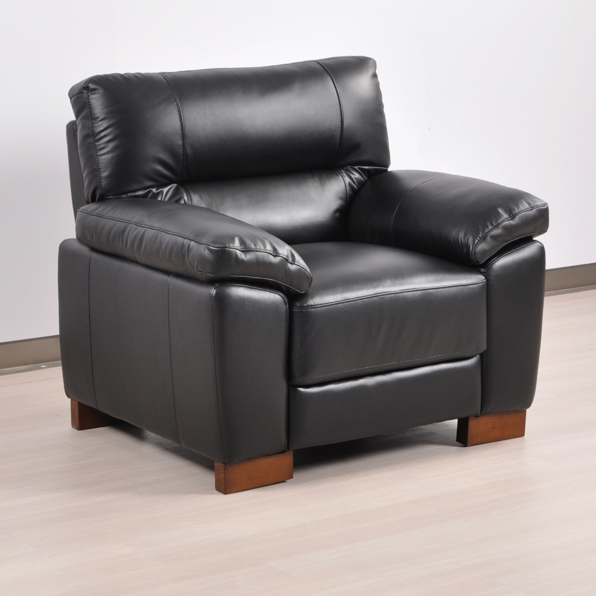 Angled view of the Dalmore Black Armchair in a modern room with soft lighting and neutral decor.