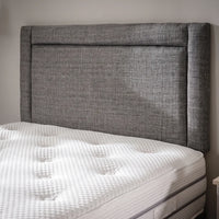 Headboard close up of grey fabric bed
