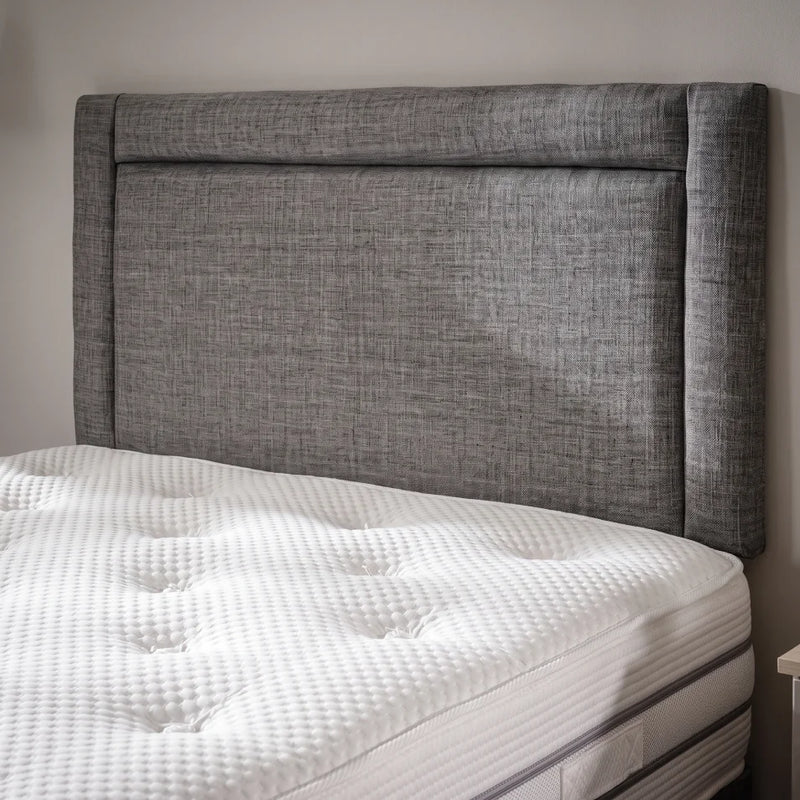 Headboard close up of grey fabric bed
