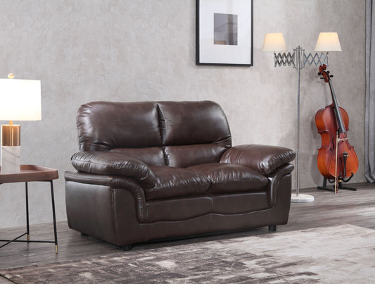 Brown leather sofa in a living room setting with a cello and lamp.