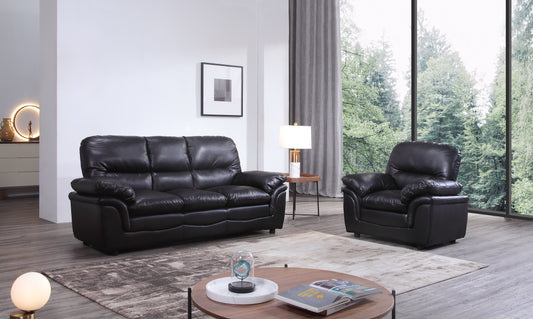 Living room with black leather sofa and chair, coffee table, and decorative items.