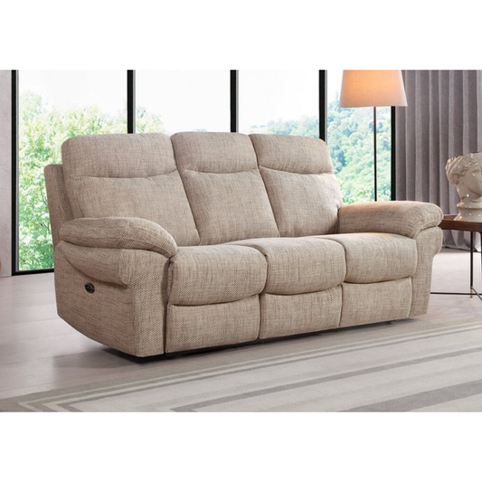 Beige reclining sofa in a living room setting with large windows and a lamp.