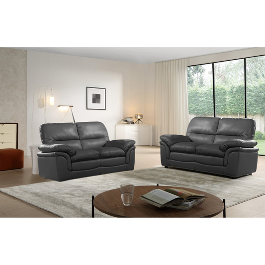 Gray leather sofa set in a modern living room with a coffee table and decor items.