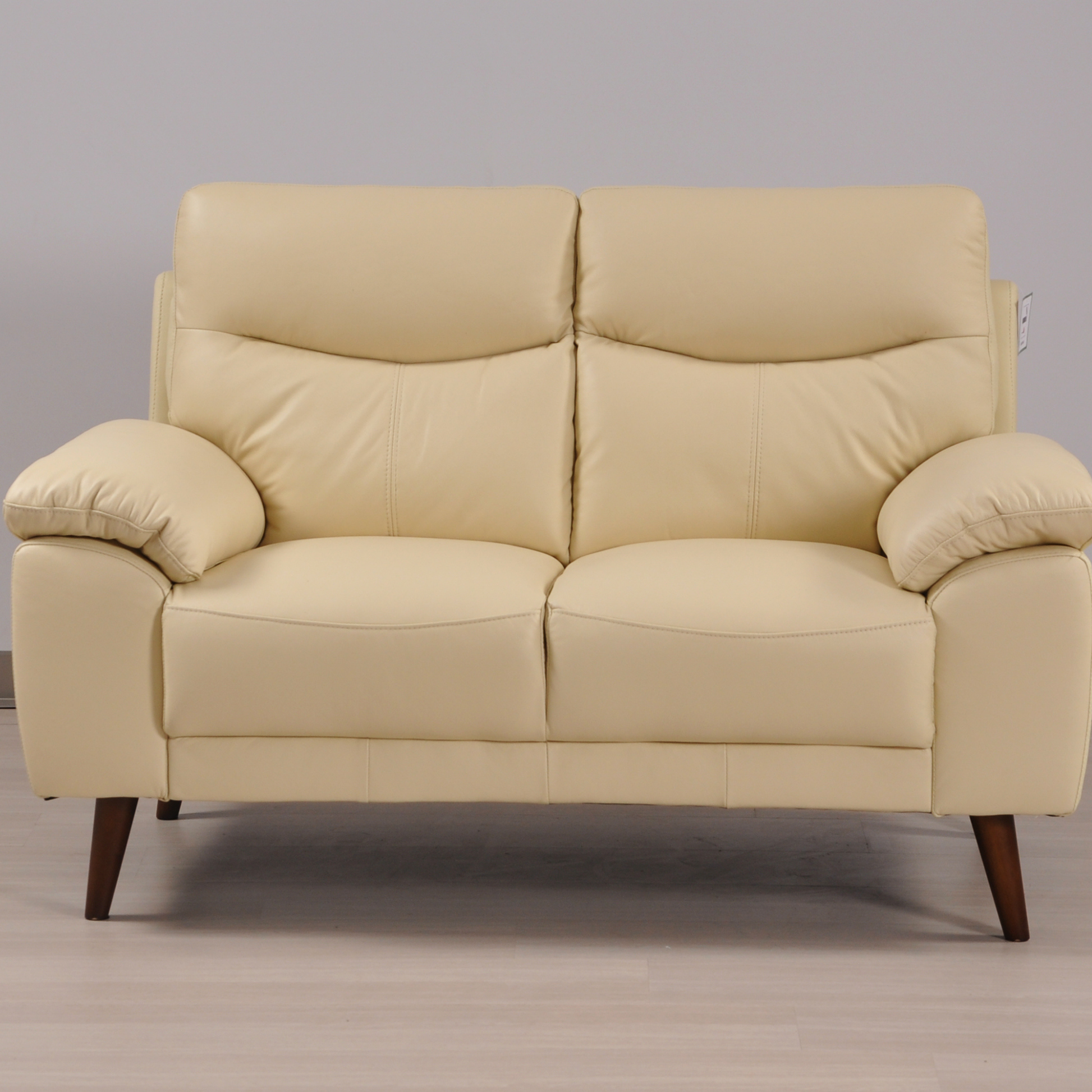 Vantage Cream 2-Seater Sofa in a modern living room setting with stylish décor, soft lighting, and neutral tones