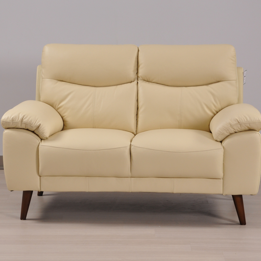 Vantage Cream 2-Seater Sofa in a modern living room setting with stylish décor, soft lighting, and neutral tones