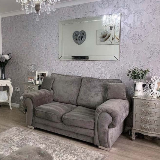 Gray sofa in a living room with decorative elements and wallpaper.